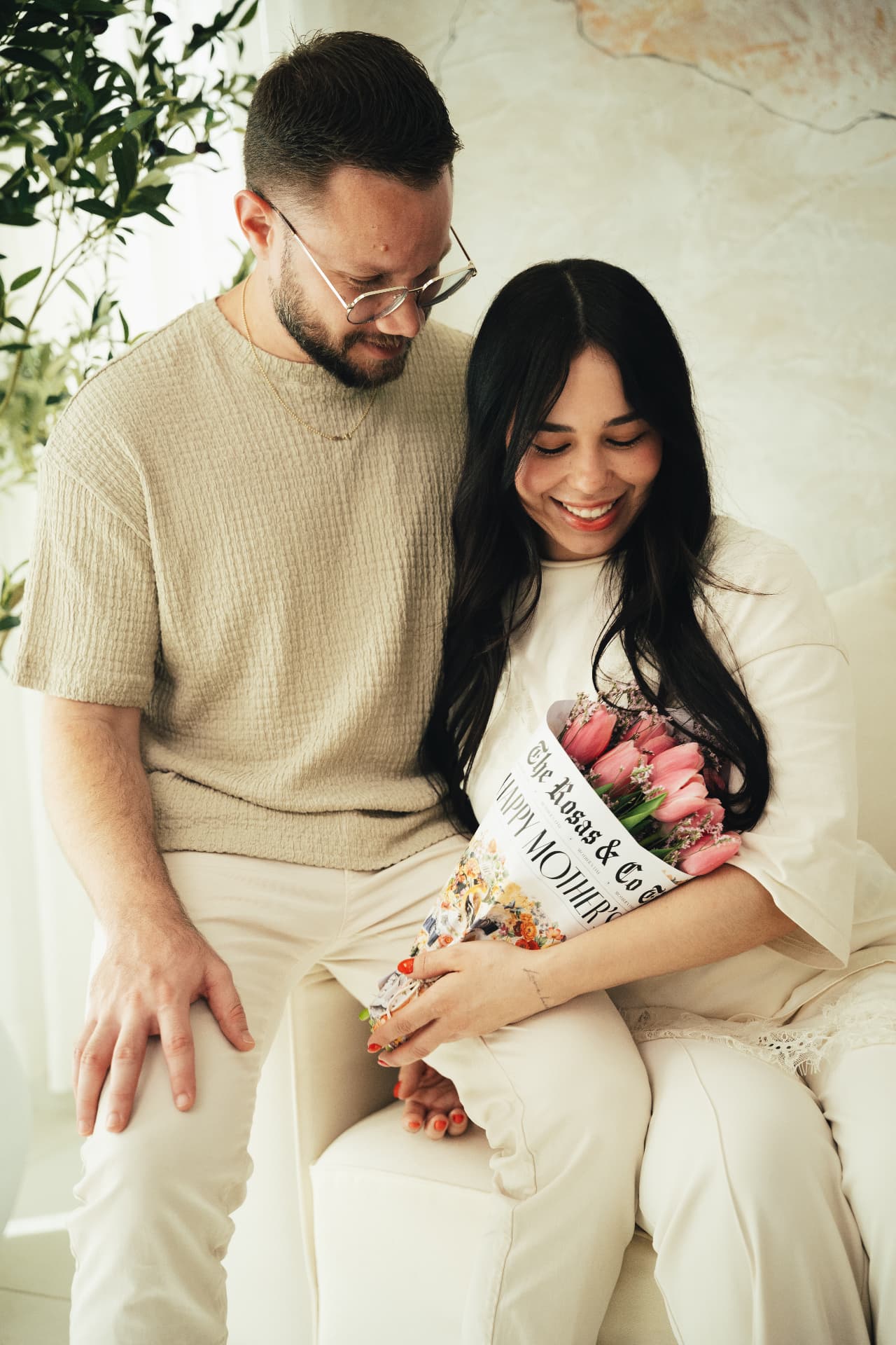 Couple holding a Rosas & Co. newspaper-wrapped tulip bouquet